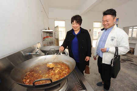民建临沂市委市直一支部会员看到爱心厨房为孩子们准备的午餐，开心地笑了.jpg