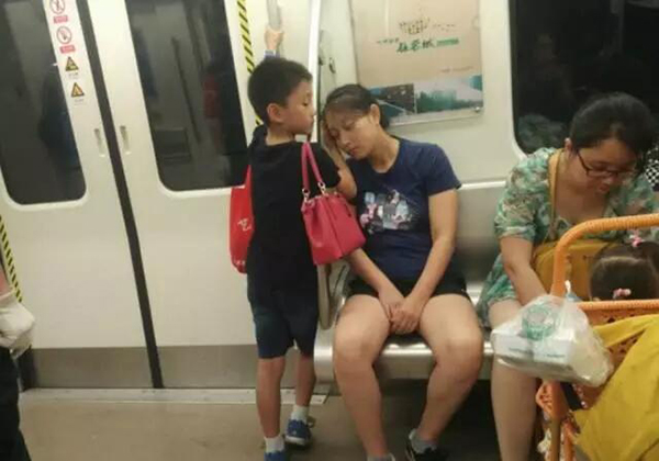 04：把座位让给中途上车的带着小宝宝的阿姨后，小男孩用手垫住了妈妈靠在扶柱上的头，背过了妈妈手中的包。他说：“我已经长大了，这是应该的。”.jpg