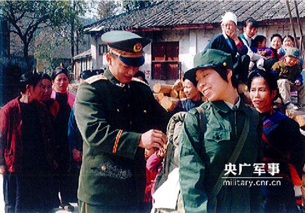 武警红瑶女童班毕业的凤秀娟，成为了红瑶族中第一个“女军人”，临当兵前何方礼给她整理背囊。.jpg