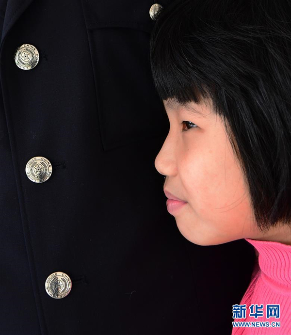 在福建省晋江市育婴院，一名小女孩趴在公安民警的怀里撒娇.jpg
