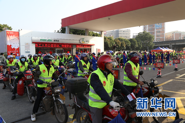 在中国石化龙山加油站，上百辆“返乡摩骑”正有序排队等待加油，并穿上了现场志愿者送上的安全背心和围巾.png