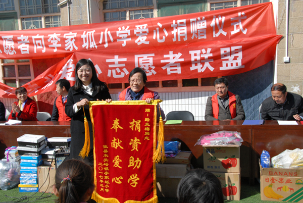李家坬小学为爱心志愿者路生梅（右）赠送锦旗。_副本.jpg