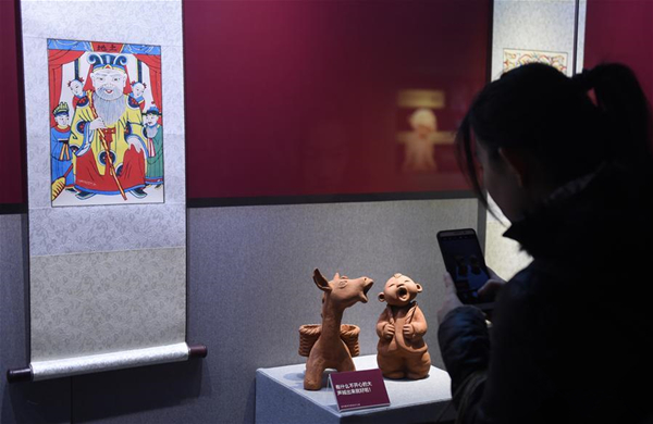 2月8日，一名观众用手机拍摄展出的“曲阳泥塑”和“武强年画”。.jpg