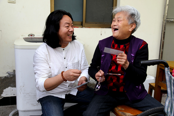 老人拿着凌万兵送来的照片开怀大笑。.jpg