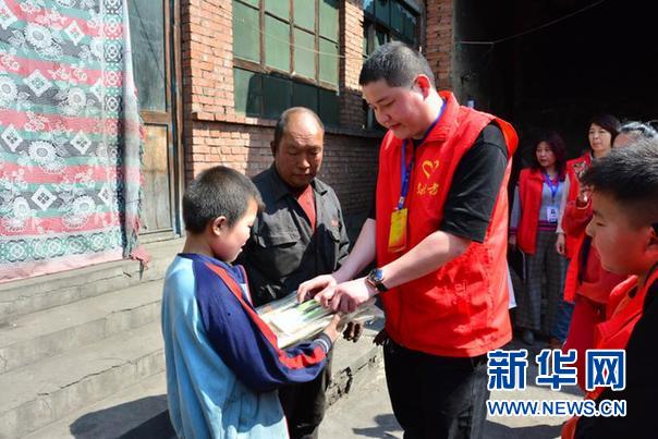图为志愿者为受助学生送去图书等物资.jpg