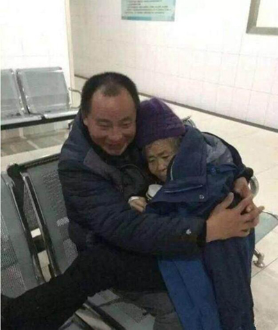 一名医生拍下了一男子在山东费县人民医院候诊区怀抱老母亲为其取暖.jpg